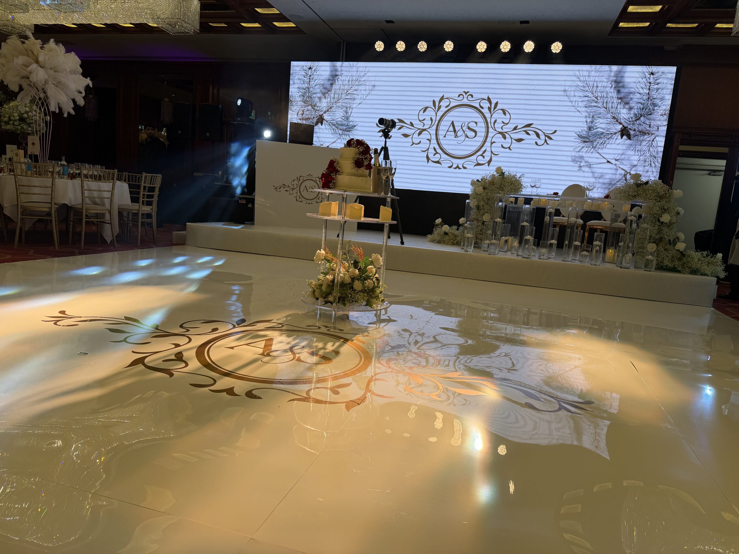 Seamless white LED dancefloor with personalised monogram projection at luxury wedding recption