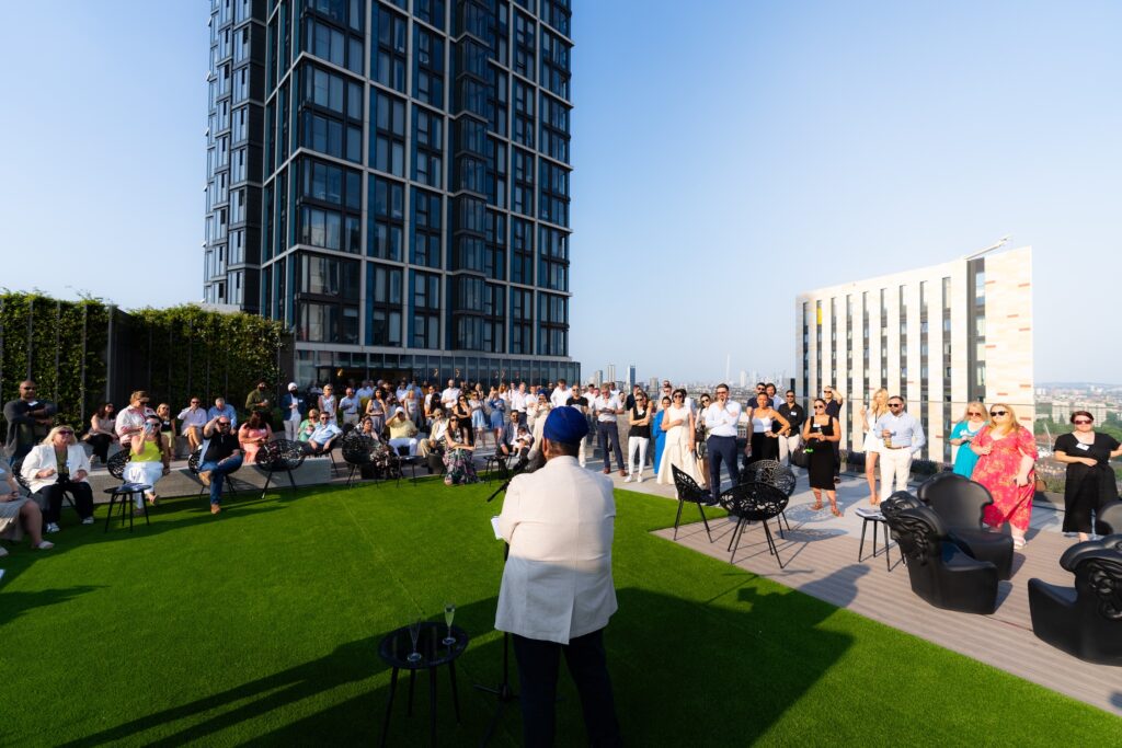 Corporate rooftop networking event with large audience and skyline in London